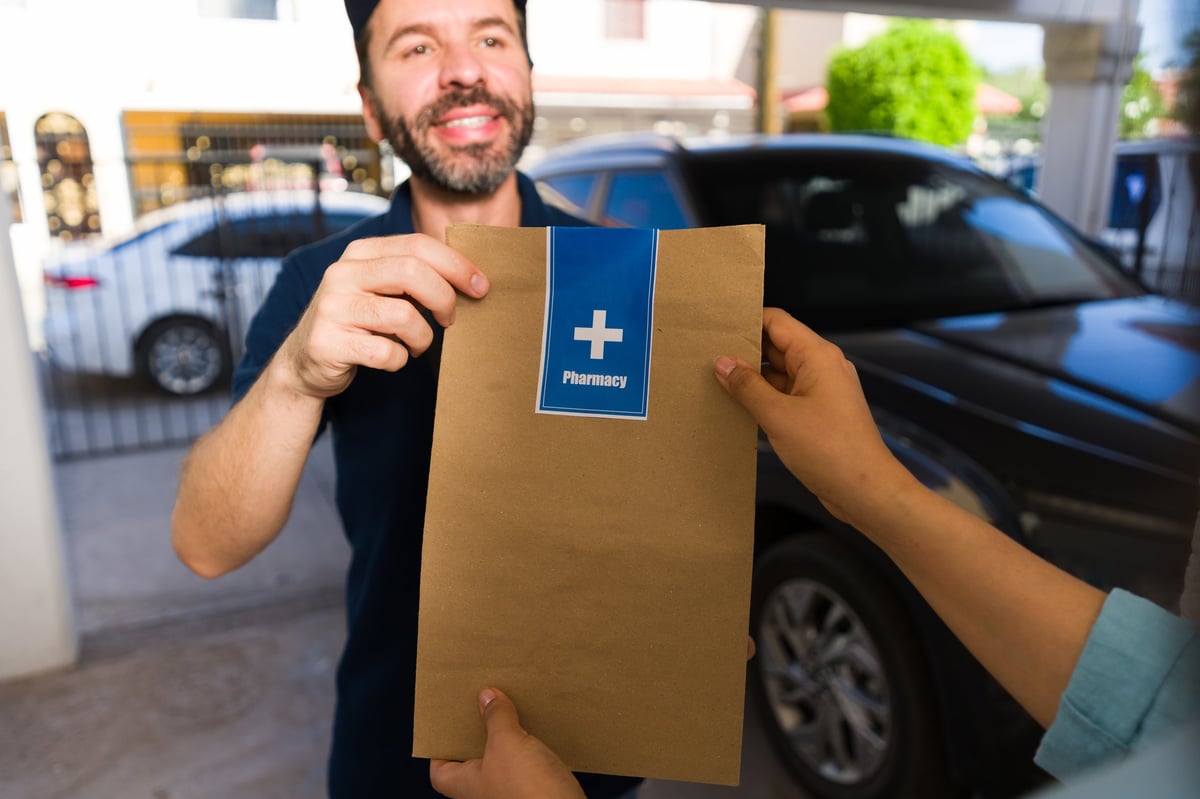 Courier delivering a pharmacy package with a medical label to a patient at home
